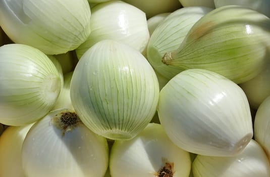 Large fresh peeled onions are ready to be chopped into pieces