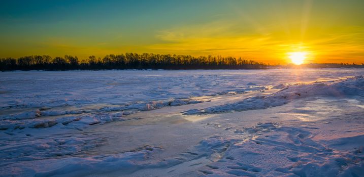 The sun is rising on the icy Dnieper River
