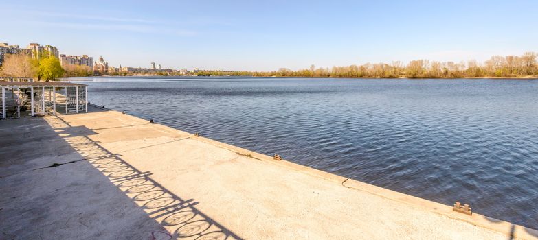 Concrete jetty with mooring cleats on the Dnieper River in the Kiev district named Obolon at the beginning of spring