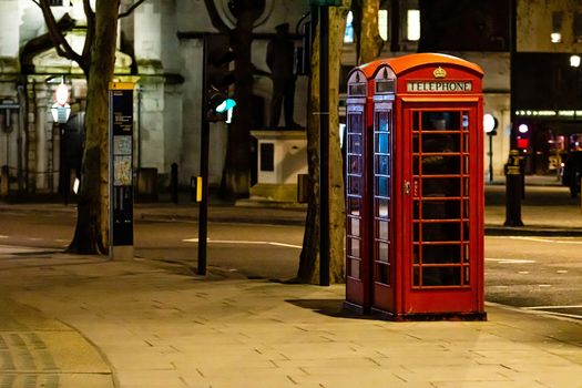 London, England, UK - January 2, 2020: red Telephone Booth at night, red phone booth is one of the most famous London icons