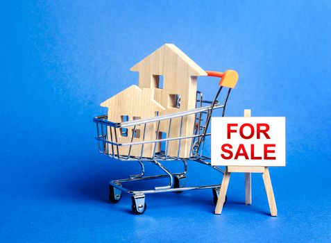 Houses in a shopping cart and an easel sign labeled for sale. Buying and selling real estate, hot offers and property valuation. Smart investments. Discounts and great offers, cheap loans for purchase