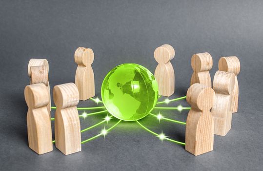 People surrounded a green globe planet earth. Cooperation and collaboration of people around the world. Outsourcing and joint work on projects. Diplomacy. crowdfunding. Preserving environment