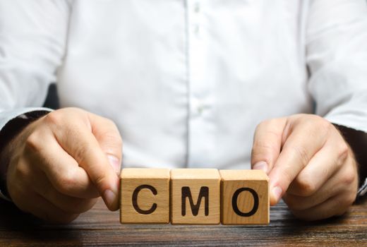 Man holds abbreviation CMO. Marketing strategy of the company. Post top manager Chief Marketing Officer. PR and advertising, establishing public relations and the media