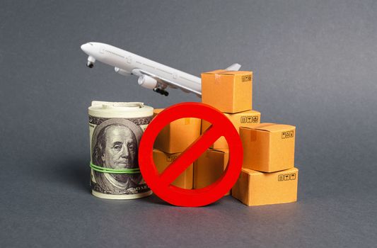 The prohibition sign NO blocks, bundle of dollars money and boxes with a airplane. Embargo, trade wars. Restriction on importation goods, proprietary for business. Sanctions and economic restrictions