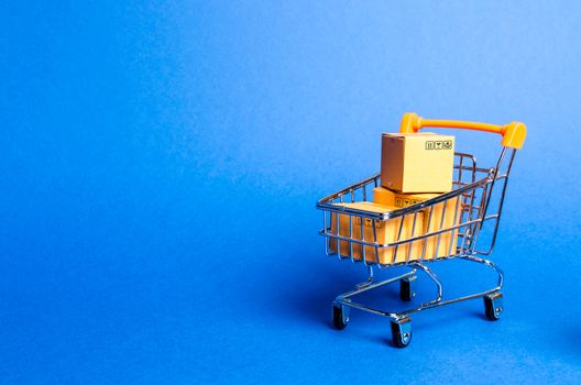 Supermarket cart with boxes, merchandise: the concept of buying and selling goods and services, internet commerce, online shopping, trade and turnover. Import and export, purchasing power.