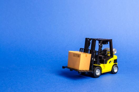 Yellow Forklift truck with cardboard box. Increase sales, production of goods. transportation, storage of cargo. Freight shipping, delivery of goods. logistics industries. retail. copy space