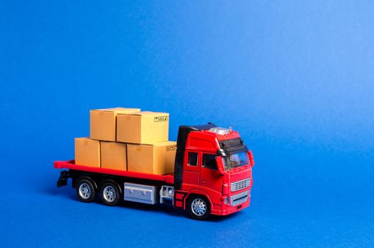 A red truck loaded with boxes. Services transportation of goods and products, logistics and infrastructure. Transportation company. Warehousing and supply. Optimization of delivery logistics.