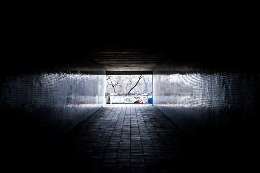 A dark underpass with graffiti on the walls