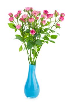 Bunch of tiny pink roses in a blue ceramic vase isolated on white background