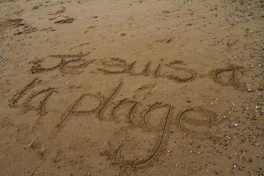 Je suis a la plage written on a beach during fog