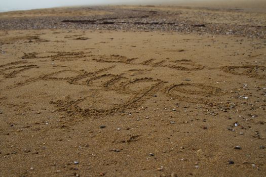 Je suis a la plage written on a beach during fog