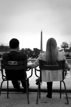 A young couple sat down in France looking down Champs Elysee’s