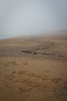 Je suis a la plage written on a beach during fog