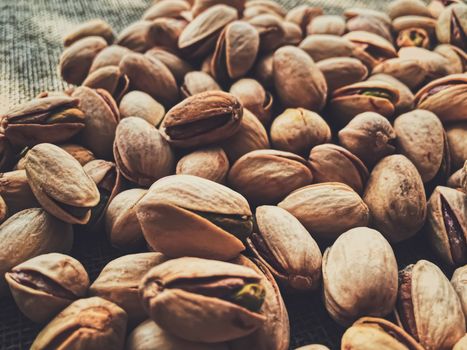 Pistachio nuts on rustic linen background, food and nutrition