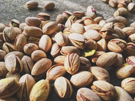 Pistachio nuts on rustic linen background, food and nutrition