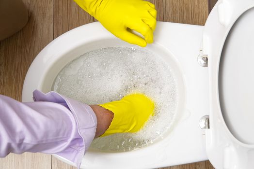 Man cleaning overflowing broken toilet. clogged toilet
