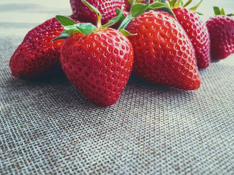 Organic strawberries on rustic linen background, fruit farming and agriculture