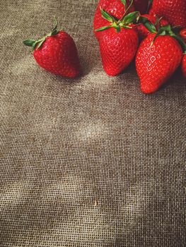 Organic strawberries on rustic linen background, fruit farming and agriculture