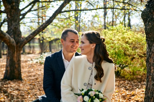 Couple in love close-up portrait. Young male and woman just married. Concept of happy family. Modern family outdoor. Adorable family demonstrate love and care. Autumn vacation.