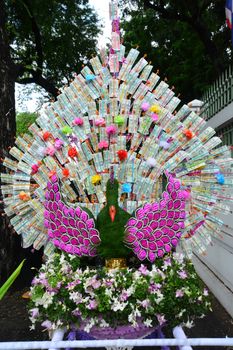 Money decorate is peacock at a buddhist temple in Thailand where financial donations are placed in order to receive merit and good fortune