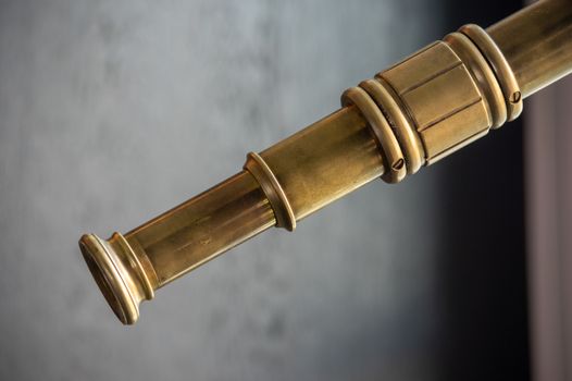 Detail of old nautical brass telescope looking into the sky