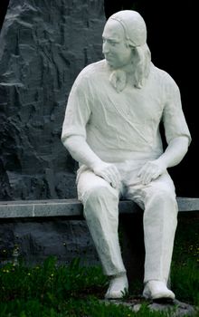 Statue of Nikolaus Ludwig, Reichsgraf von Zinzendorf und Pottendorf teaching children while sitting on a stone bench in a park.