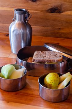 school lunch packed in stainless steel lunchbox on wooden surface