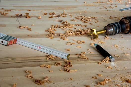 High angle view on woodworking tools laying on a wooden surface with wood shavings laying around