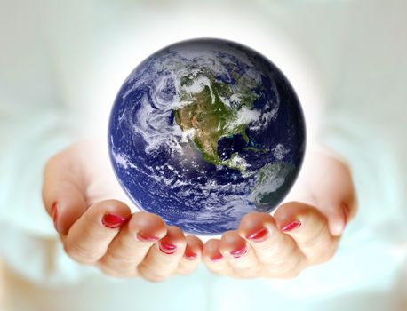 two women's outstretched arm and above the Earth