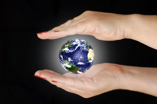 Earth between two women's hands