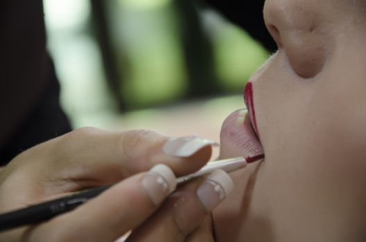 Woman in a hairdressing putting on makeup