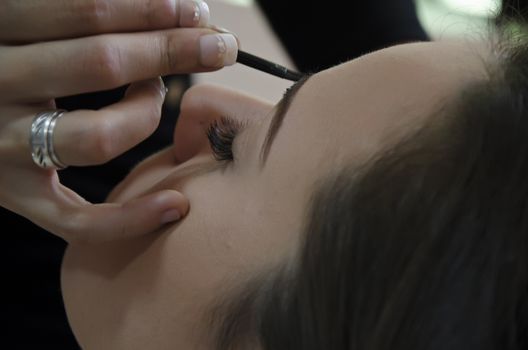 Woman in a hairdressing putting on makeup