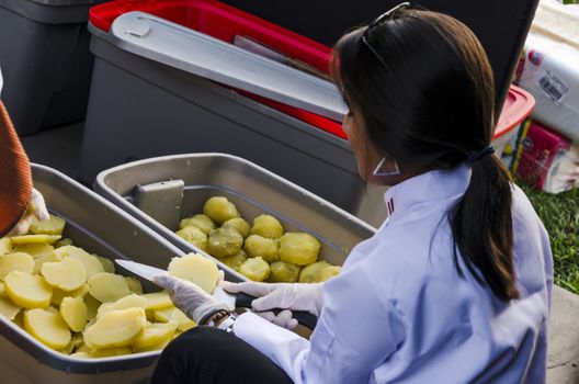 Woman cutting potatoes in a basket