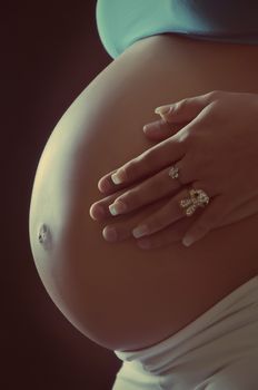 Cropped image of beautiful pregnant woman and her husband hugging the tummy