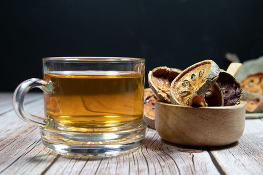 Dried Bael Fruit and Bael Fruit Juice in clear glass Place on the table It has properties to cure heat, relieve thirst, provide freshness.