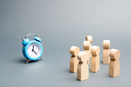 A crowd of people looks at the clock. Attention people are chained to the clock. Waiting for events over time. Relocation hours. Work day and hourly pay. Limited offer, time limit. Selective focus