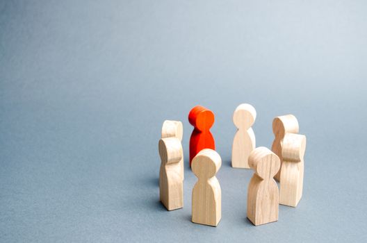 People stand in a circle on a gray background. Communication. Business team, teamwork, team spirit. Wooden figures of people. A circle of people. discussion, cooperation, cooperation. Selective focus