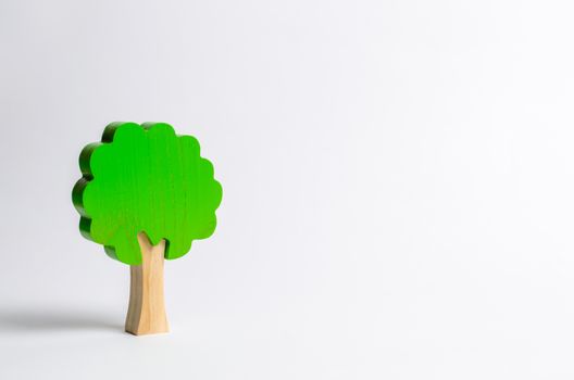 Toy wooden tree on a white background. Minimalism and the concept of environmental conservation. lungs of the planet. Family tree, a symbol of strength and wisdom. Illegal deforestation.