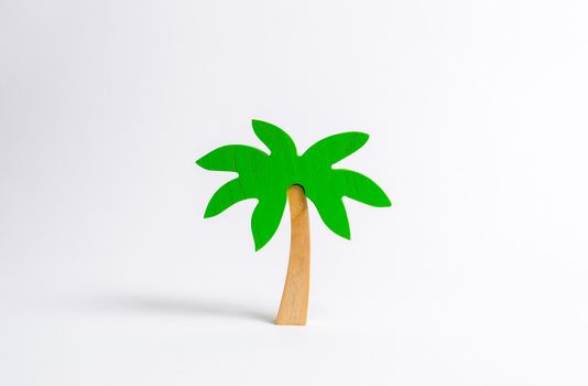 Wooden palm tree on a white background. Tours and cruises to warm countries. The development of tourism. Tropical island. Conceptual leisure and vacation, entertainment and relaxation.