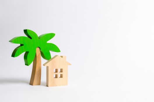 Wooden palm tree and hut on a white background. Conceptual leisure and vacation. Rental homes and properties in the resort. Romantic travel. Entertainment and relaxation.