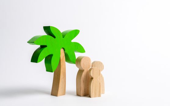 Wooden palm tree and family. Family holidays with children. Tours and cruises to warm countries. The development of tourism. Tropical island. Conceptual leisure and vacation, entertainment