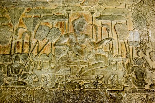 Bas relief sculpture of King Suryavarman II surrounded by subjects with parasols and fans. Angkor Wat temple, Siem Reap, Cambodia.