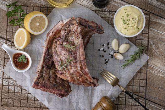 Grilled pork ribs with mashed potatoes placed on a wooden table.