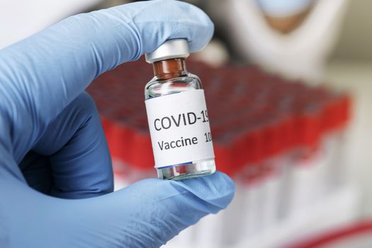 Hand holds Coronavirus Covid-19 Vaccine glass bottle. Healthcare And Medical concept.