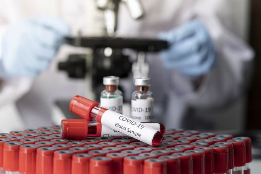 Stethoscope and blood sample vacuum tube. Covid-19 or Coronavirus Concept, Biological blood samples in test tubes and vaccine for the disease and syringe injection on a table. Laboratory test.