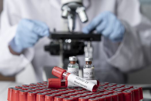 Stethoscope and blood sample vacuum tube. Covid-19 or Coronavirus Concept, Biological blood samples in test tubes and vaccine for the disease and syringe injection on a table. Laboratory test.