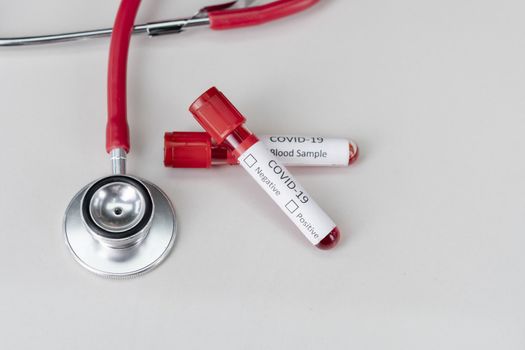 Stethoscope and blood sample vacuum tube. Covid-19 or Coronavirus Concept, Biological blood samples in test tubes and vaccine for the disease and syringe injection on a table. Laboratory test.