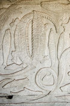 Ancient Khmer bas relief carving showing two crocodiles biting each other's tails. Gallery of the Churning of the Ocean of Milk, Angkor Wat Temple, Siem Reap, Cambodia.
