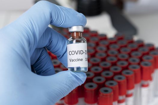 Hand holds Coronavirus Covid-19 Vaccine glass bottle. Healthcare And Medical concept.