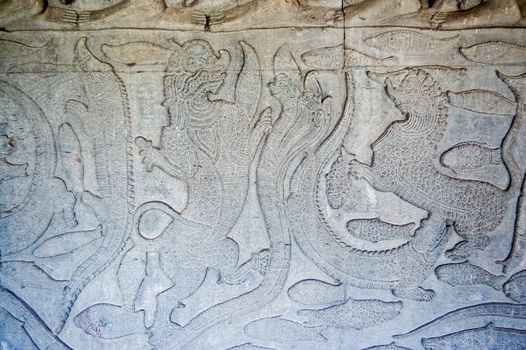 Bas Relief carving of sea serpents fighting dragons on an outer wall of the temple of Angkor Wat in Siem Reap, Cambodia.